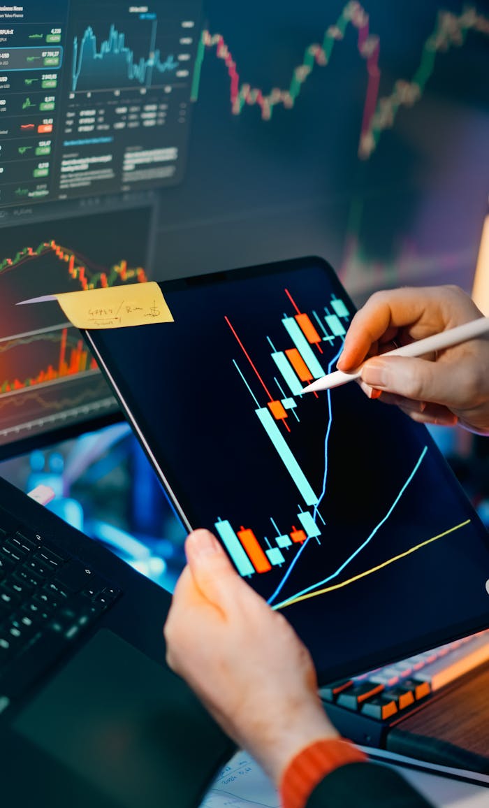 Person using a tablet to analyze financial charts for trading insights. Perfect for finance and technology themes.